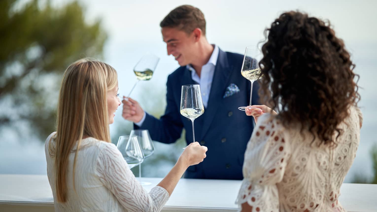 Head Sommelier Alessandro Nigro Imperiale sniffing glass of white wine with two female guests doing the same