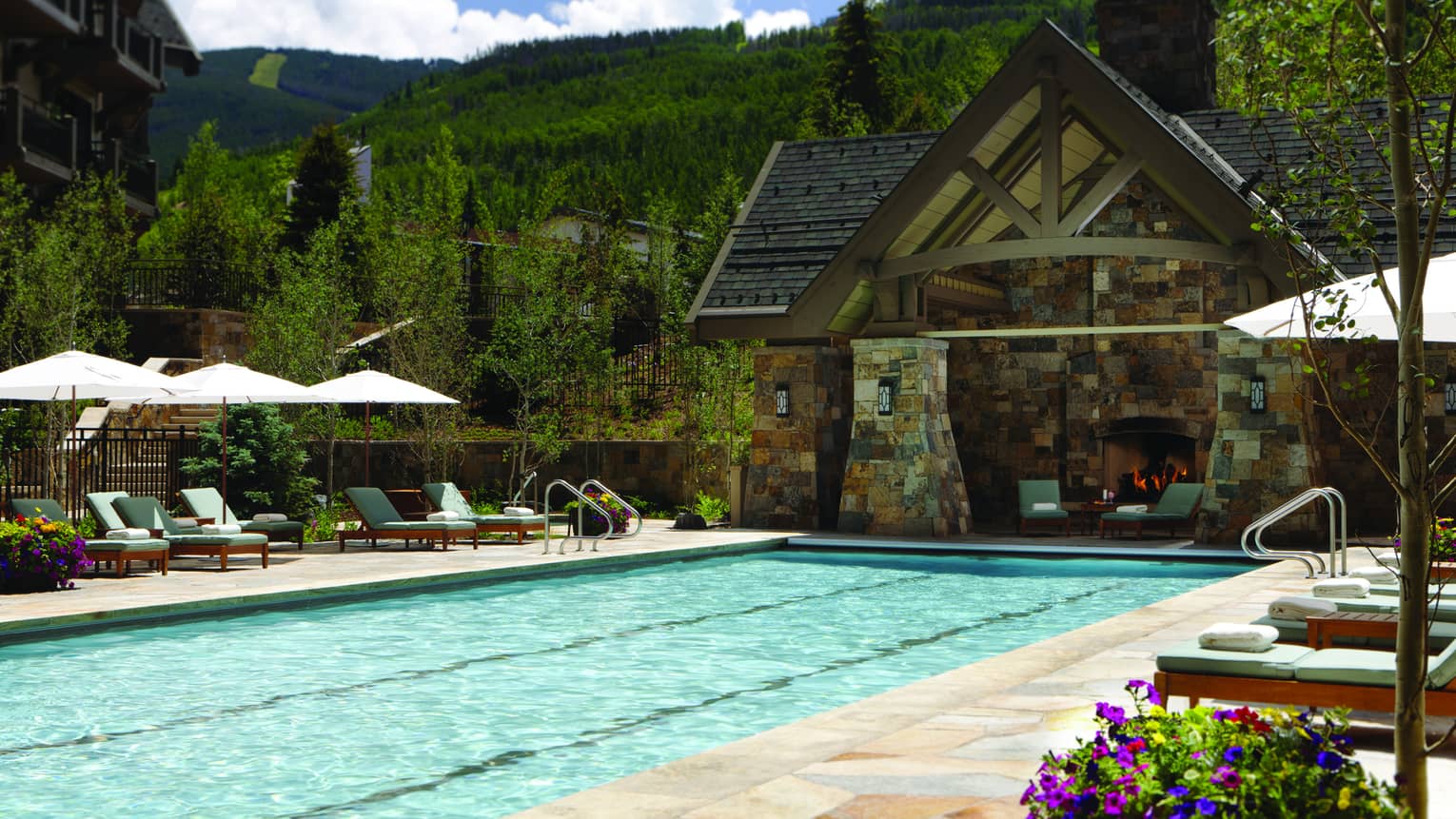 Outdoor lap pool at Four Seasons Resort Vail, lined with lounge chairs