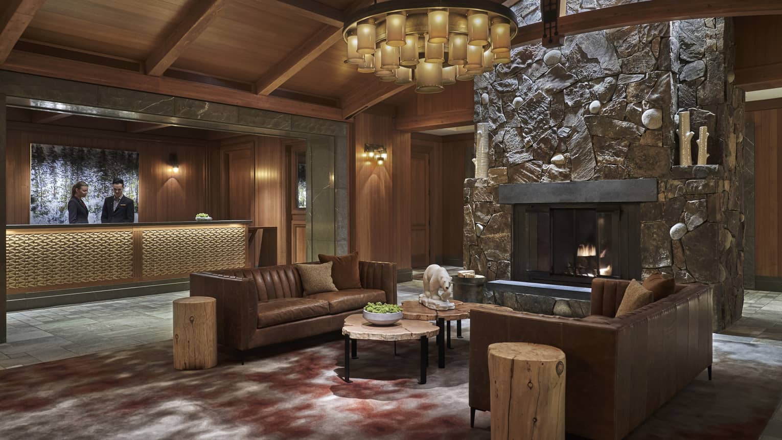 The lobby paneled with dark wood, with a couch in the centre of the room.