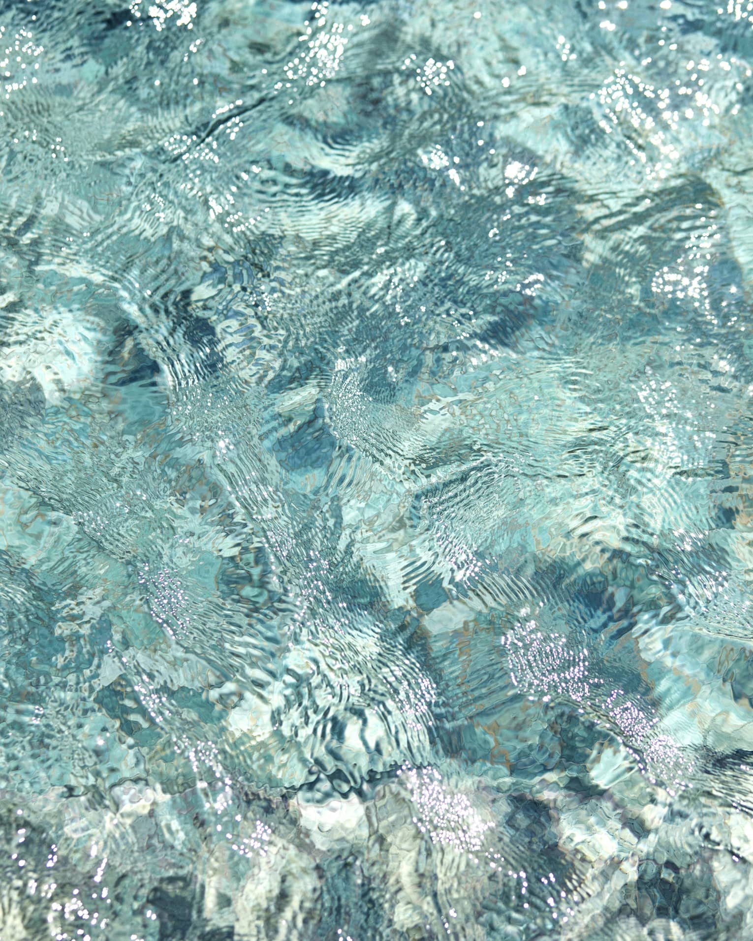 Ripples and wavelets on the surface of turquoise blue water.
