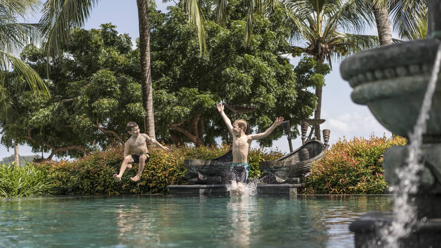 Two little boys jumping into the family pool at Four Seasons Langkawi