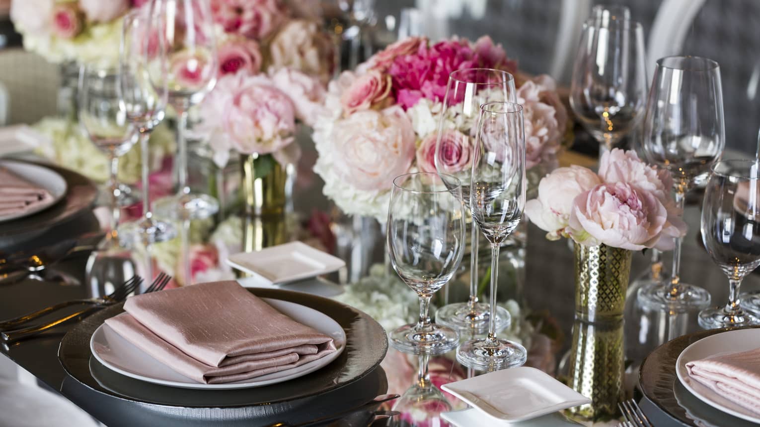 Close-up of wedding table place setting decorated with pink roses, linens 