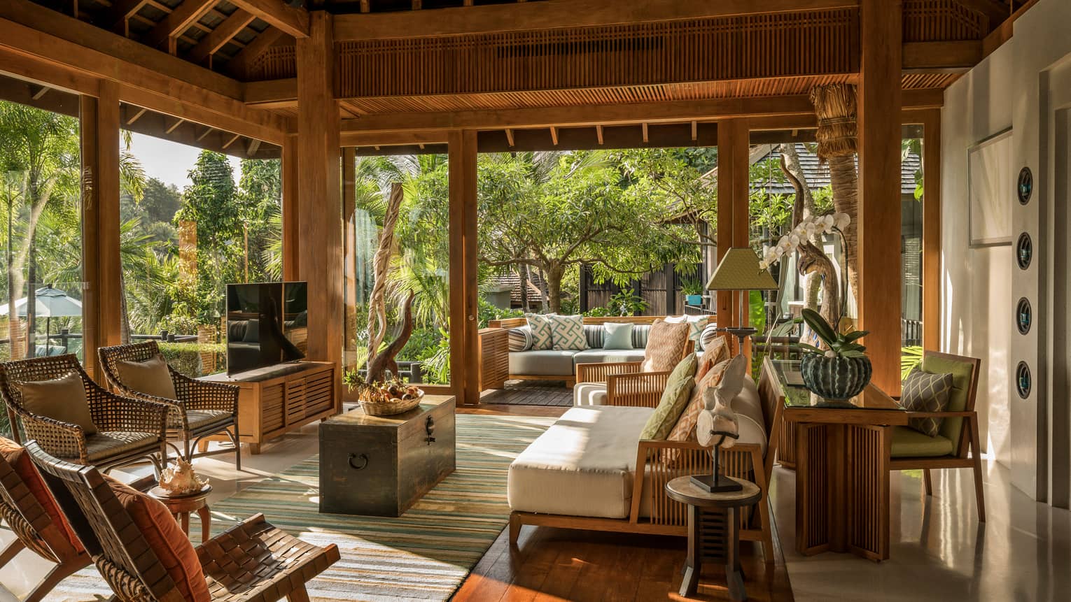 Wicker patio furniture, plush sofa under roof in open-air living room