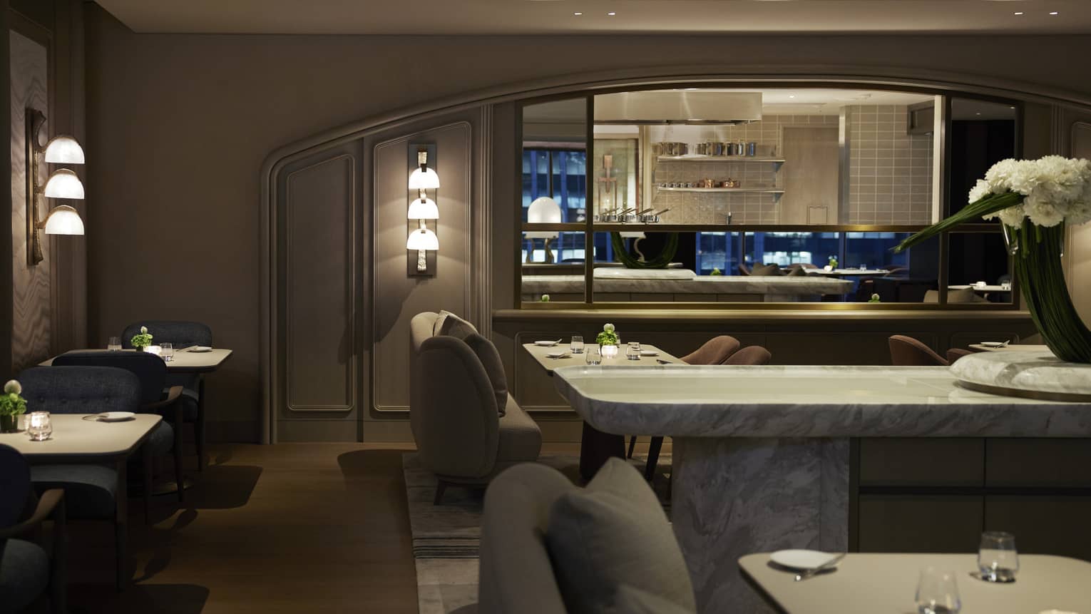 Dining room at S�ZANNE intimately lit, show kitchen visible in background