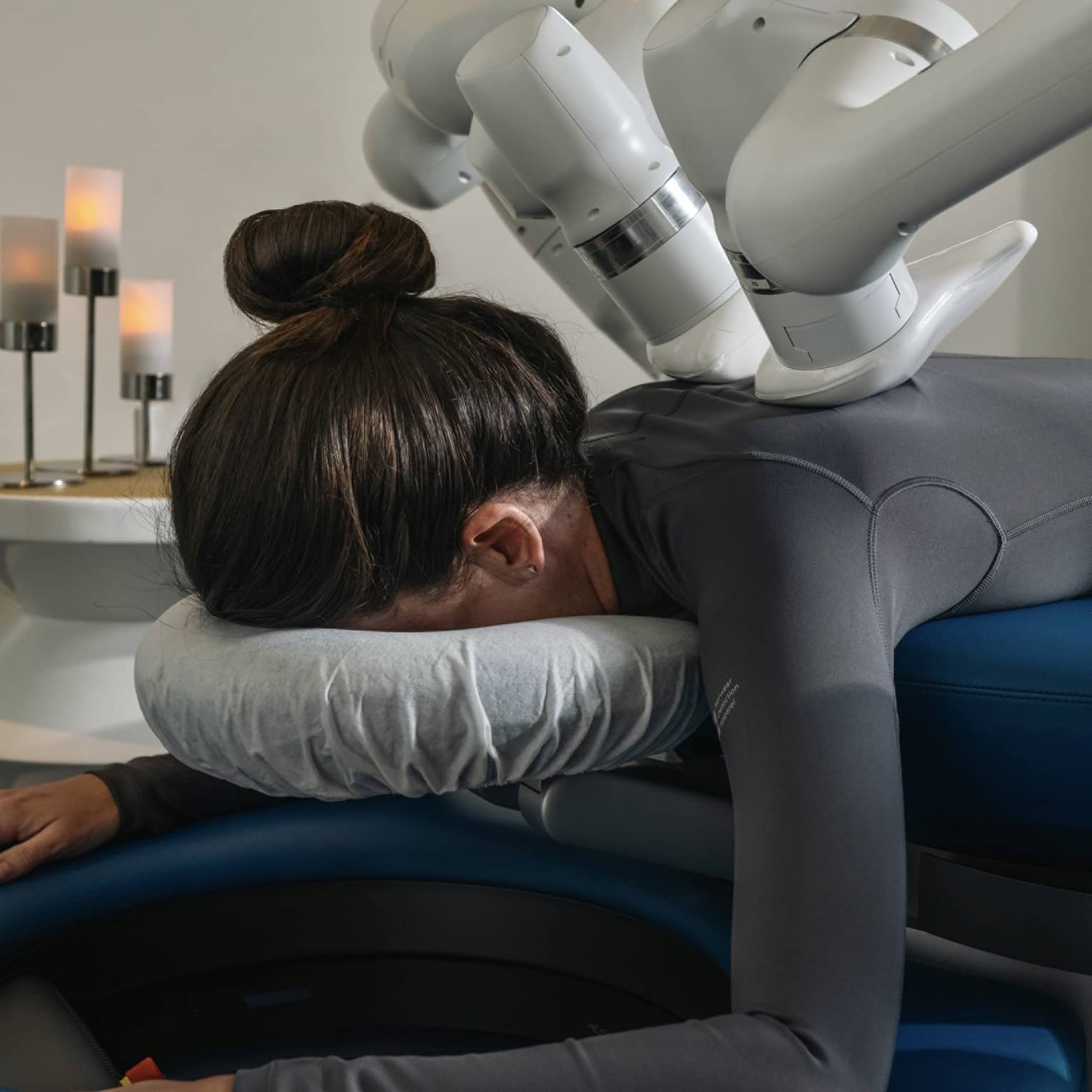 A guest laying on a massage table while getting a machined-powered massage