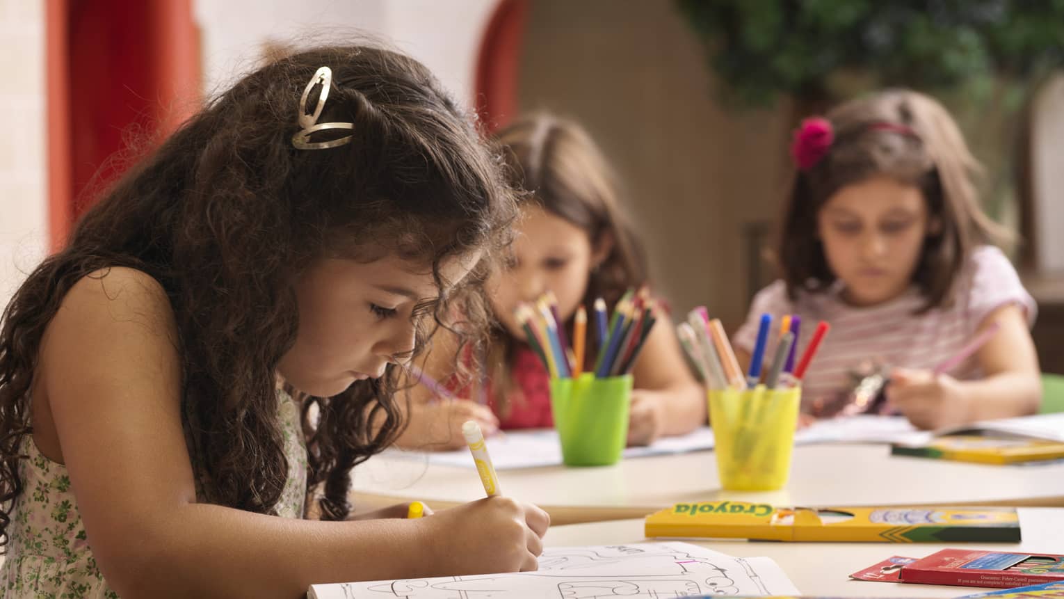 A group of young girls using markers on colouring books.