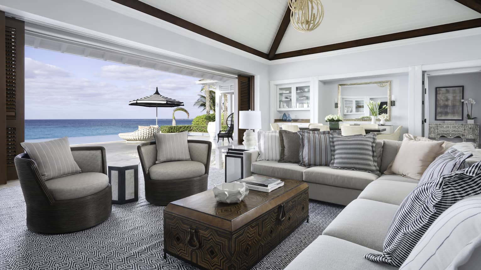 Beachfront Villa Residence large living room with modular sofa, armchairs by open wall to patio overlooking ocean