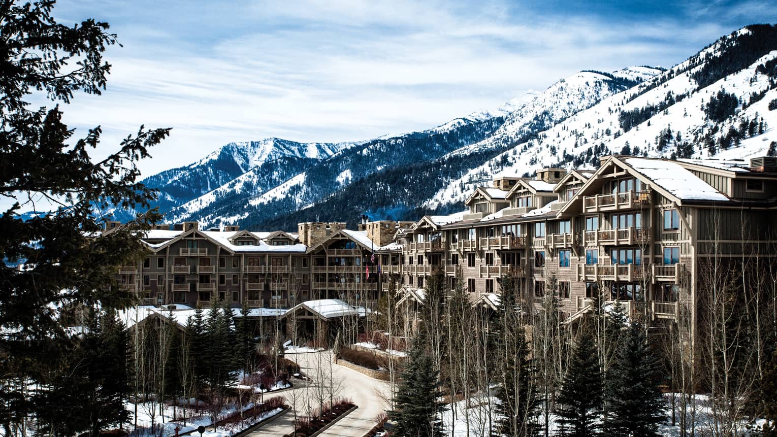 the exterior of the hotel is covered in snow and surrounded by snow capped mountains