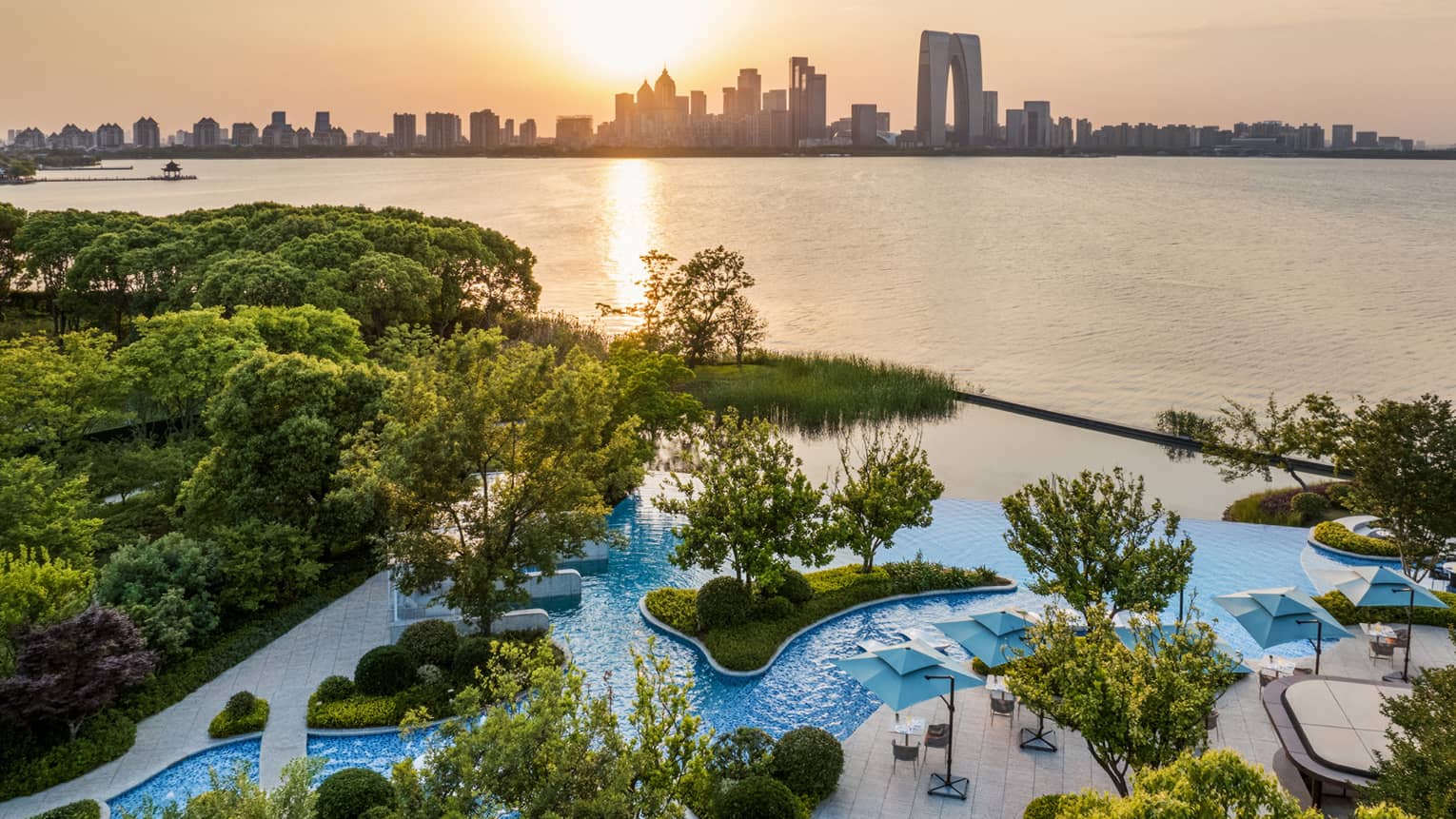 Exterior aerial shot of Four Seasons Hotel Suzhou pool grounds, with Jinji Lake and city centre in the distance