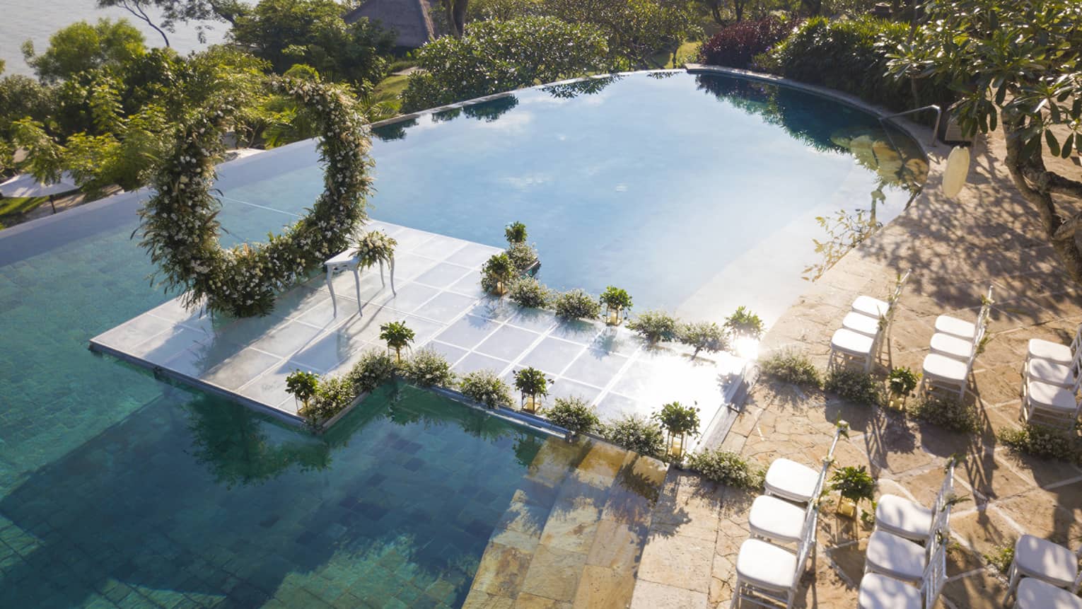 Overwater wedding venue surrounded by private pool and tropical plants 
