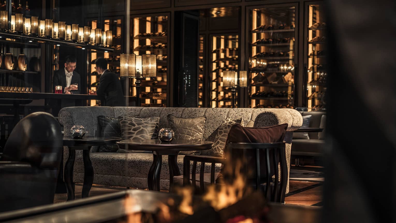 Gusto elegant sofa by small round cocktail tables, server in background