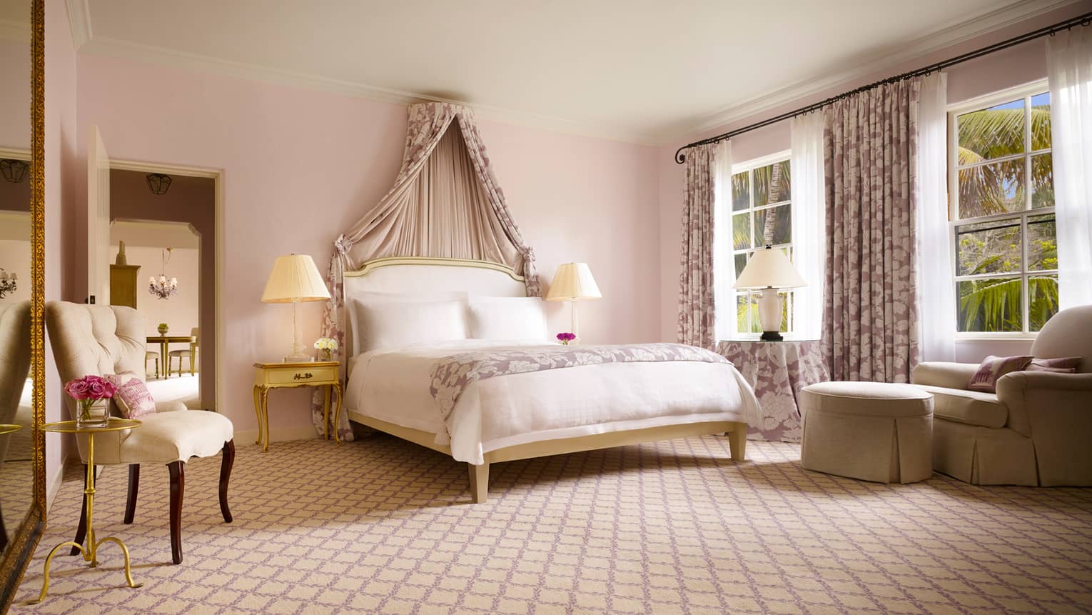 Honeymoon Suite bed with canopy over headboard, elegant white chair, armchair under windows