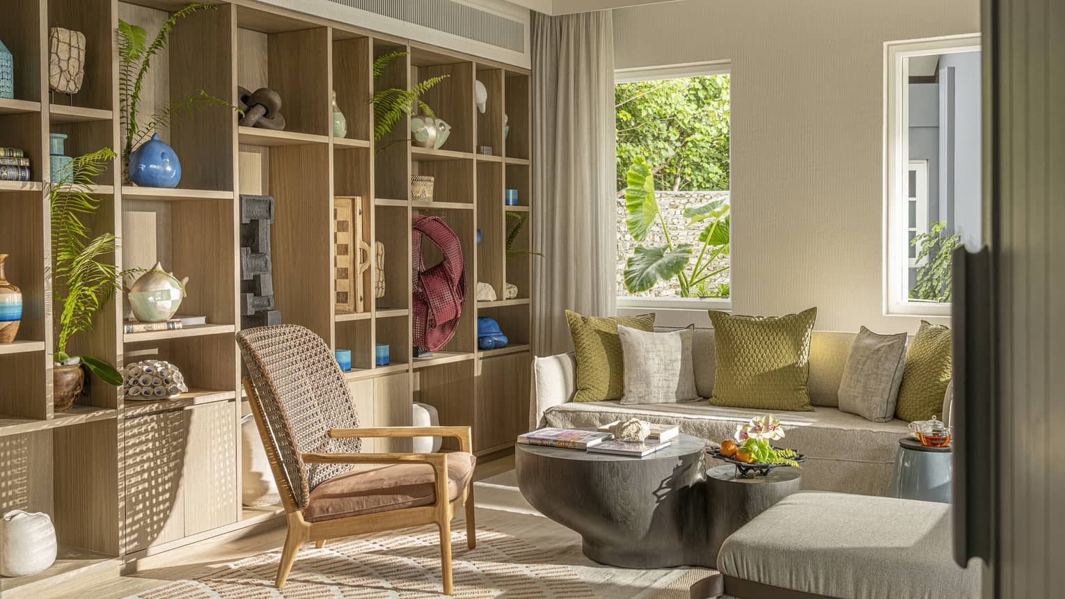 Library room in a luxury resort estate, featuring a sofa, chair and wall of shelves