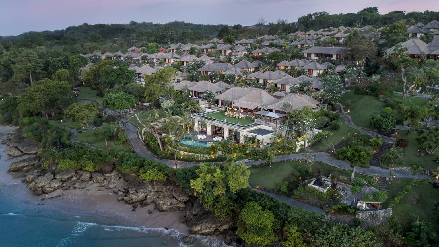 Aerial view of Bali at Jimbaran Bay resort and villas at sunset, overlooking rocks, sand beach and ocean