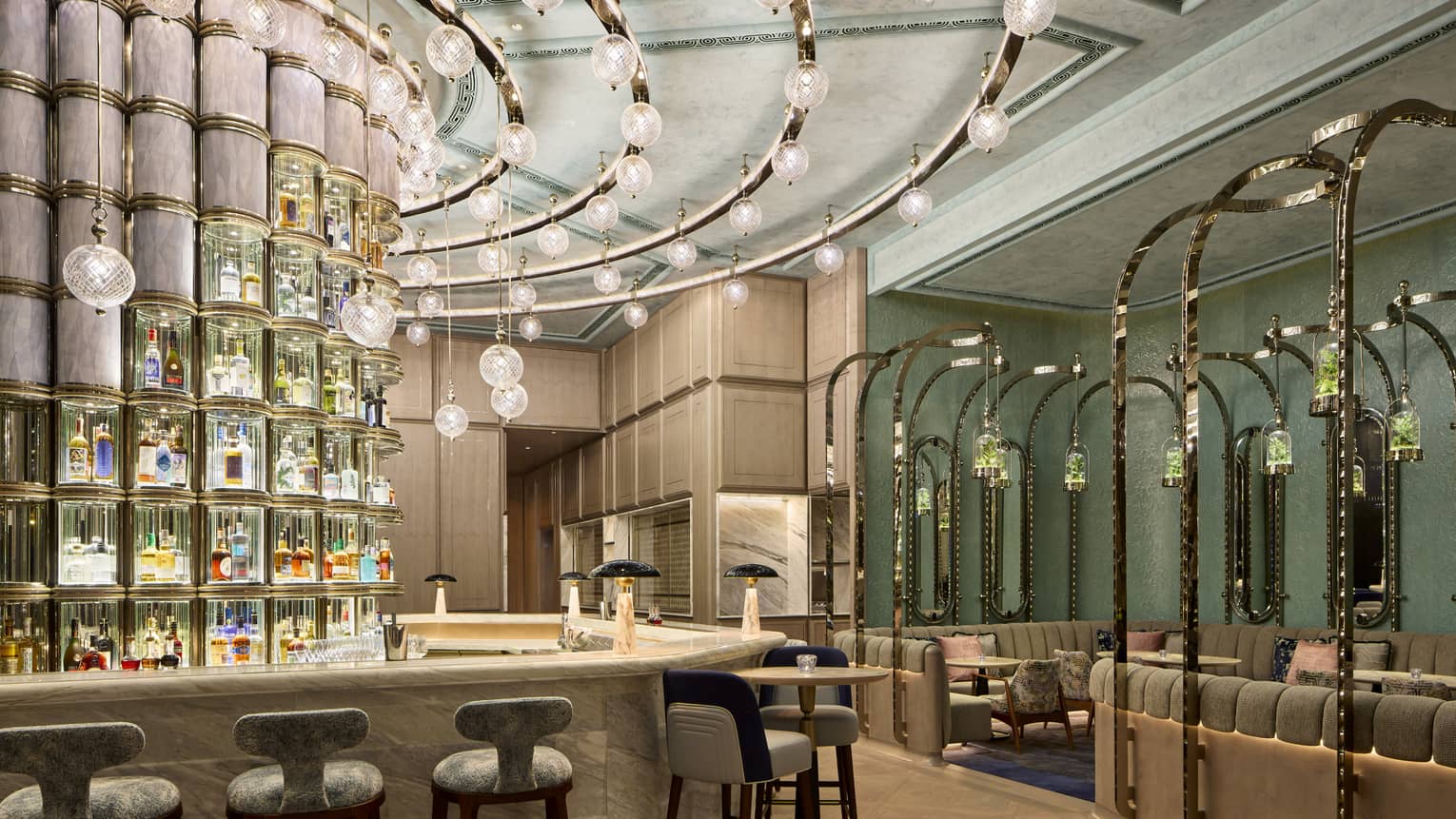 Curved bar with curved track lighting, curved wall of liquor bottles behind bar