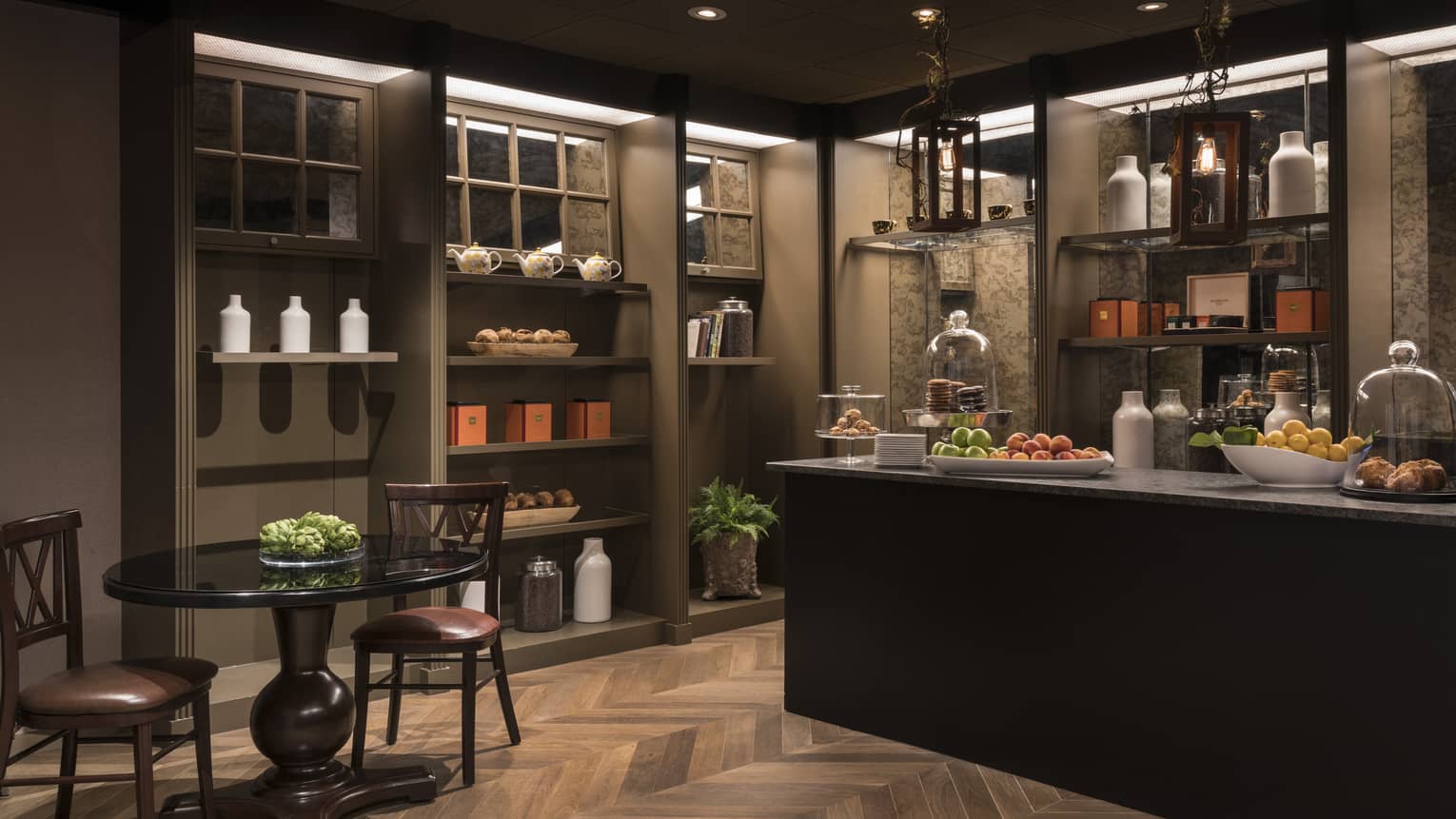 A coffee store that dimly lit with a counter and small table.