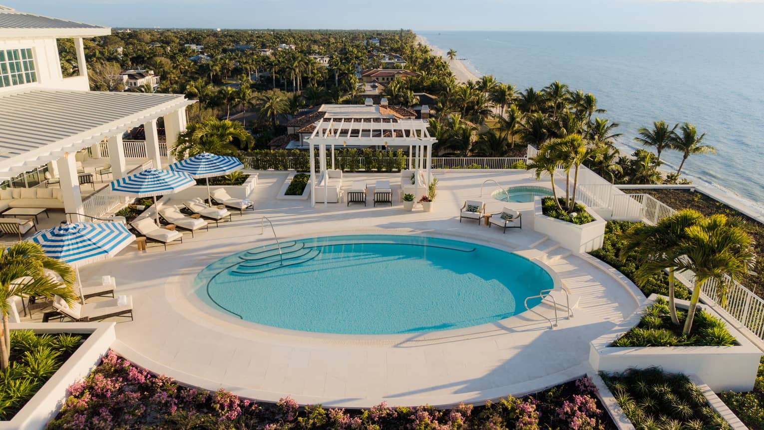 Aerial view of luxury resort suite terrace, featuring a round swimming pool with sea views