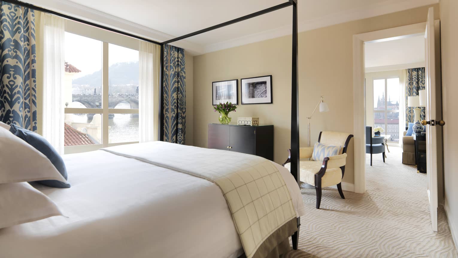 River Suite with modern ivory-coloured decor with blue accents on curtains, pillows, canopy bed frame