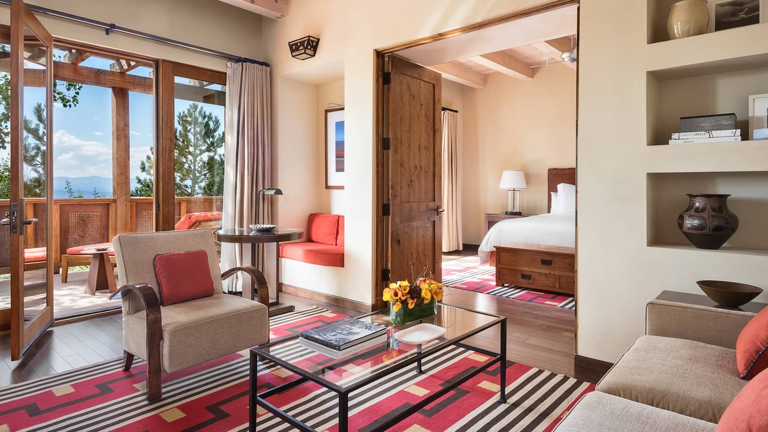 Sunset Suite living room, Southwestern-style rug, wood doors to balcony, bedroom