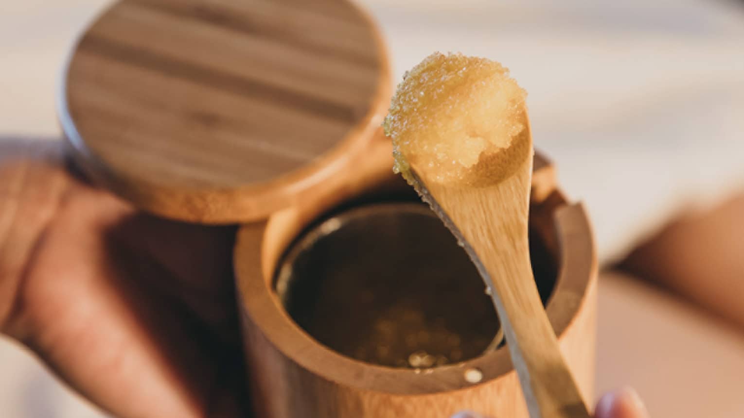 A spa staff member scoops some sugar scrub out of a bamboo container in Hawaii