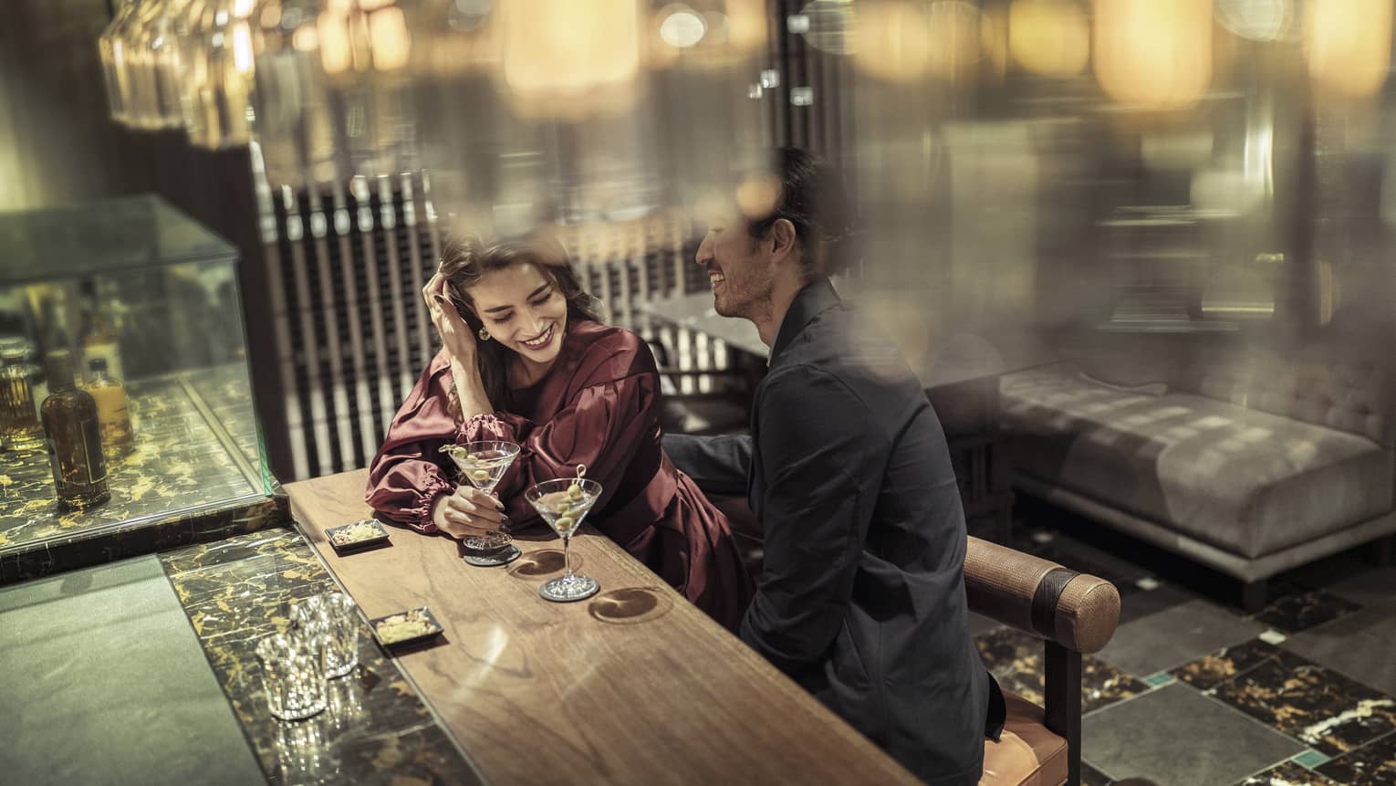 Laughing couple enjoys martinis at The Lounge 