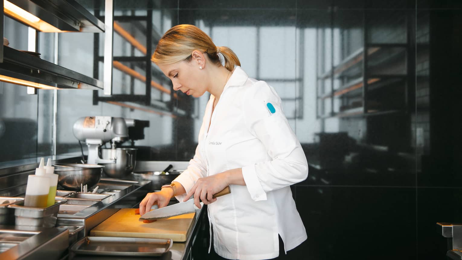 A chef using a knife in a kitchen.