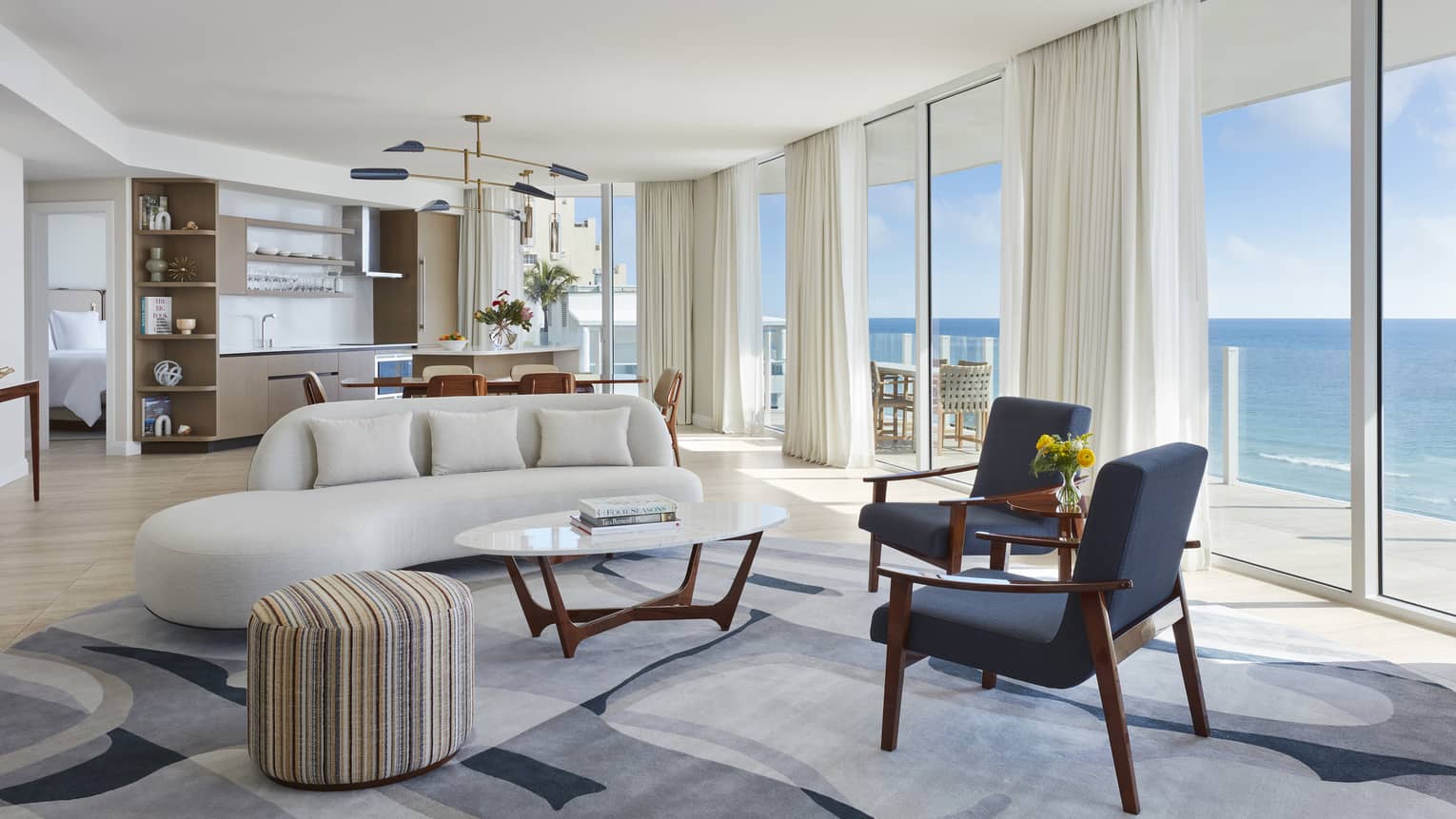 Living room and dining room with wall of windows, ocean view