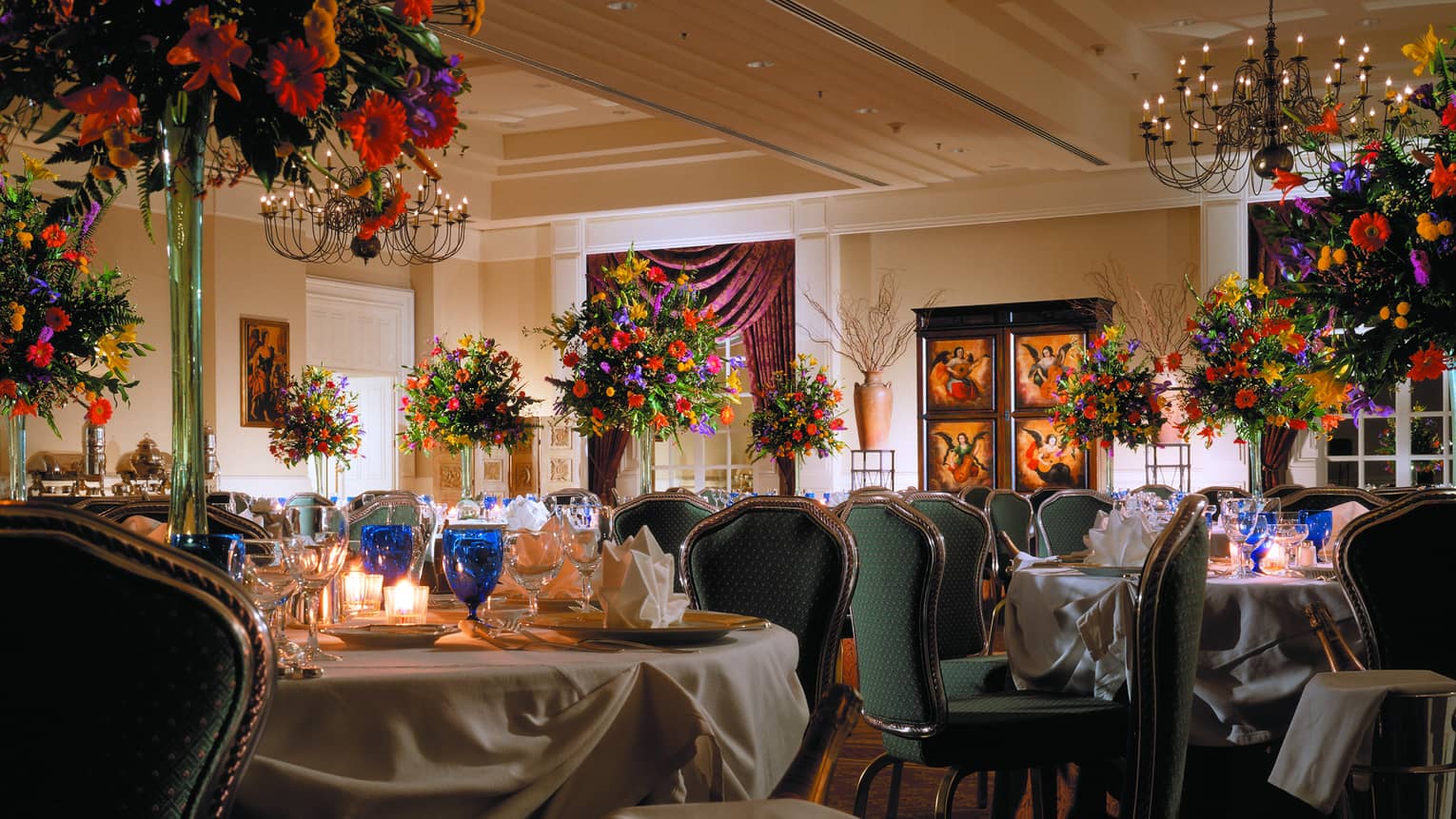 Gran Salón banquet dining tables with blue glassware, colourful flower centrepieces 