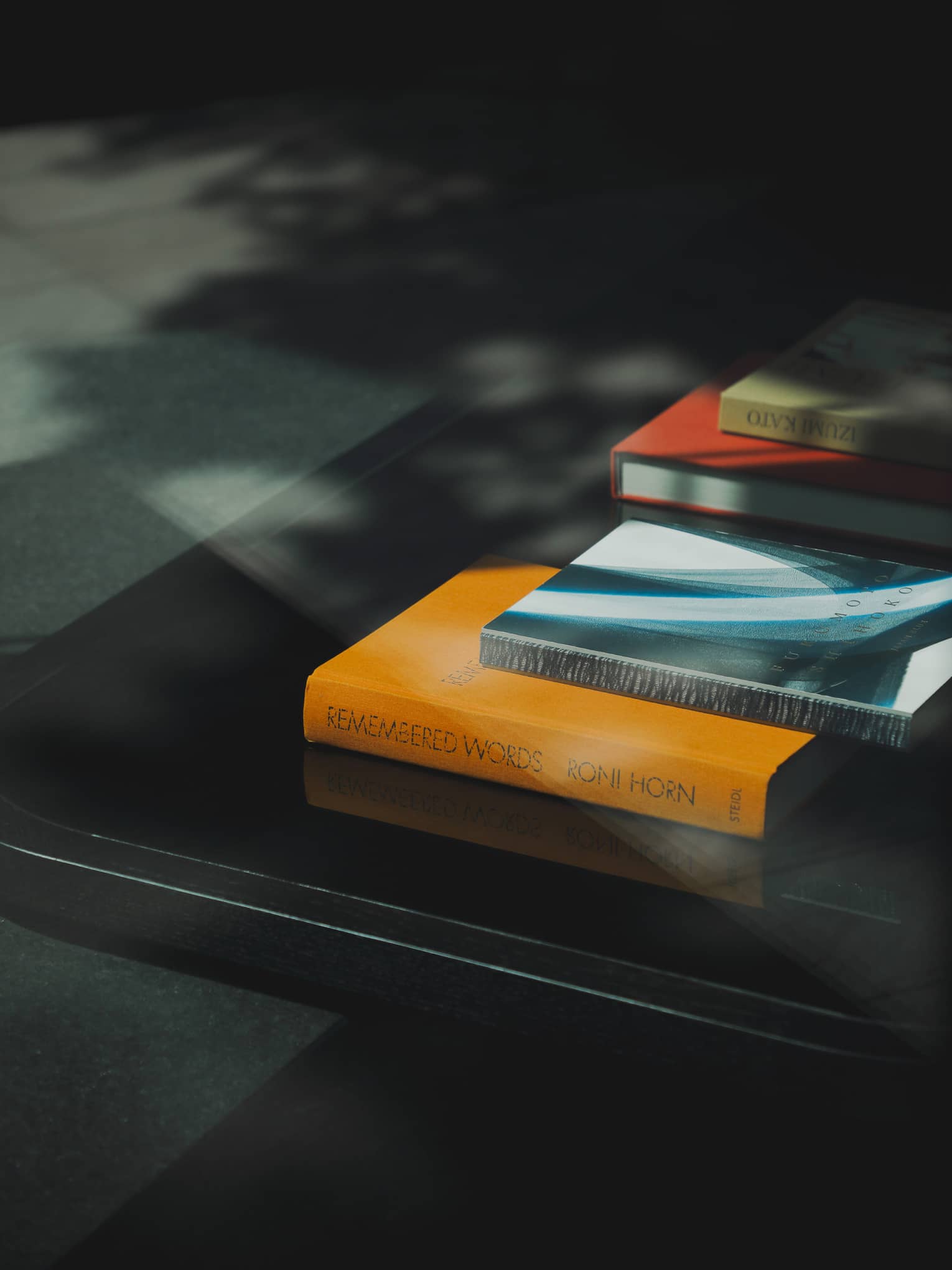 Orange, blue, red and green books stacked on a table