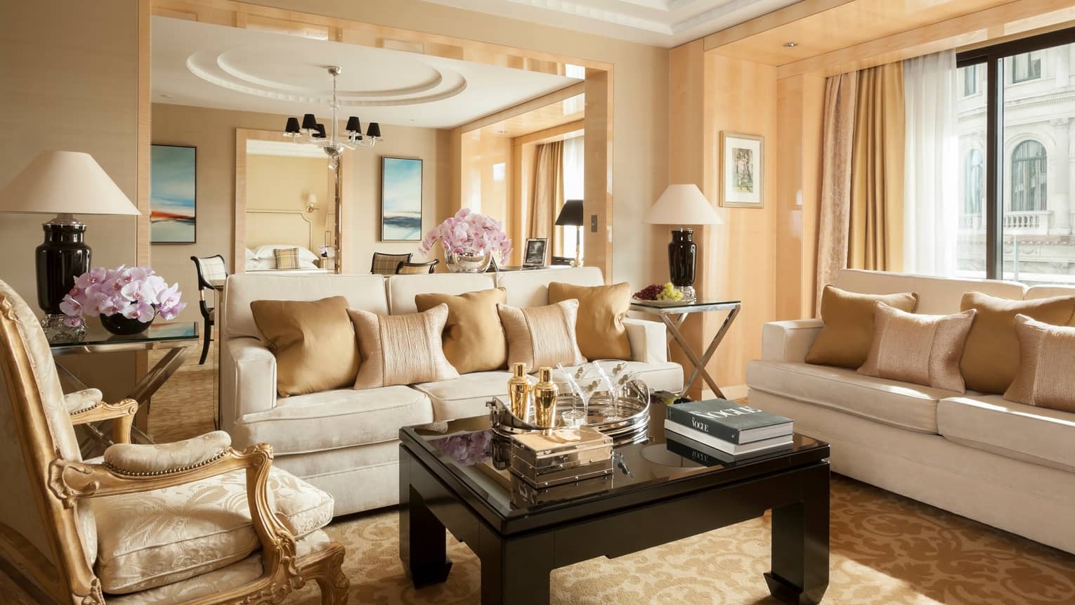 Grand One-Bedroom Suite elegant sofas, gold accent chairs under tall ceilings, dining room in background