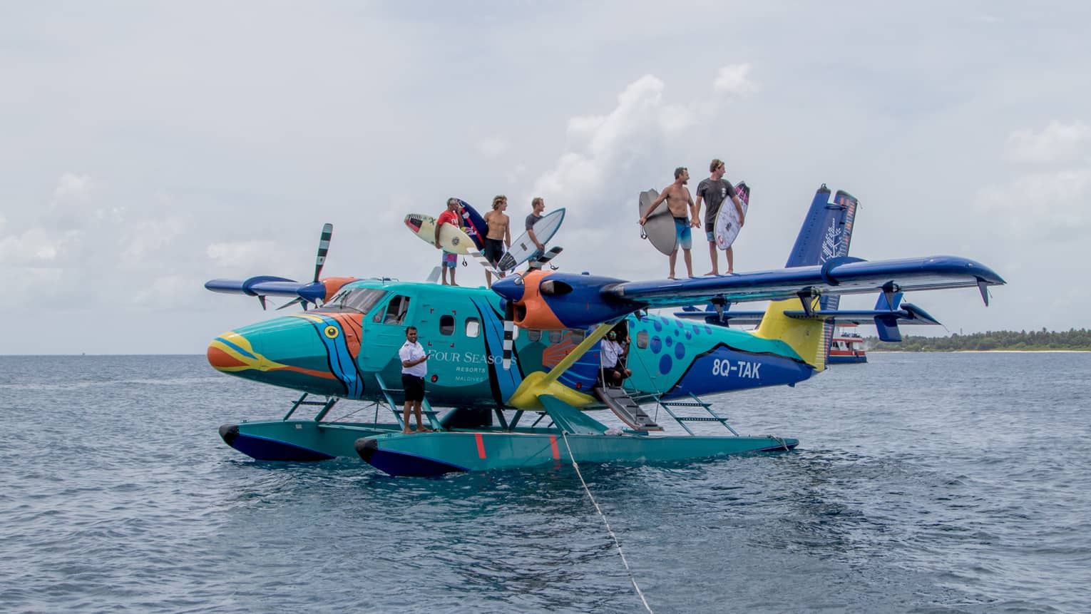 Surfers pose for camera aboard the colourful sea plane the Flying Triggerfish