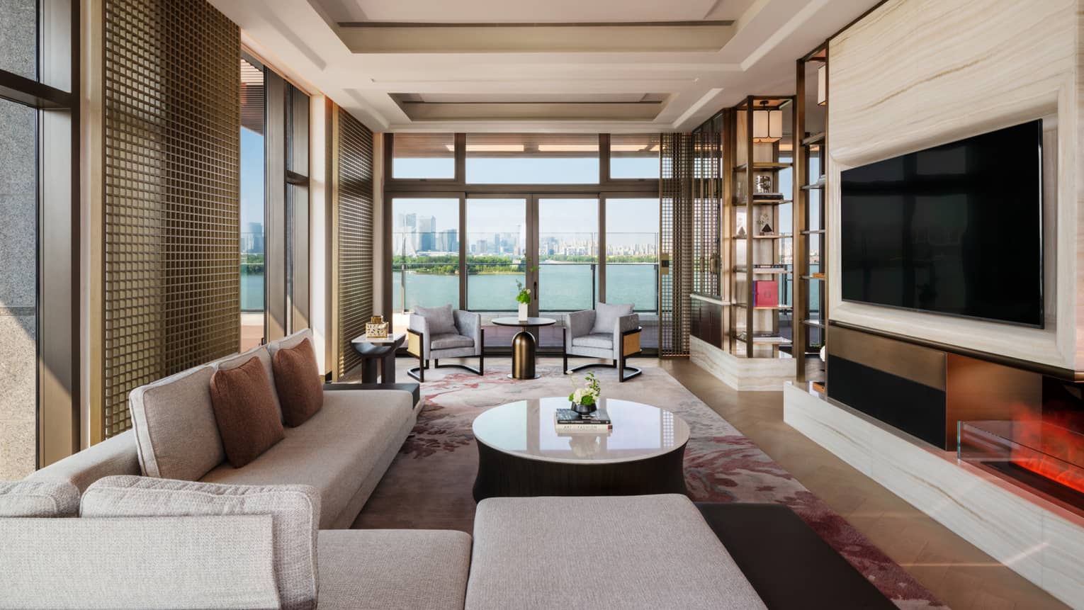 Large living room with sectional sofa, TV and lake-view terrace of Penthouse Suite at Four Seasons Hotel Suzhou