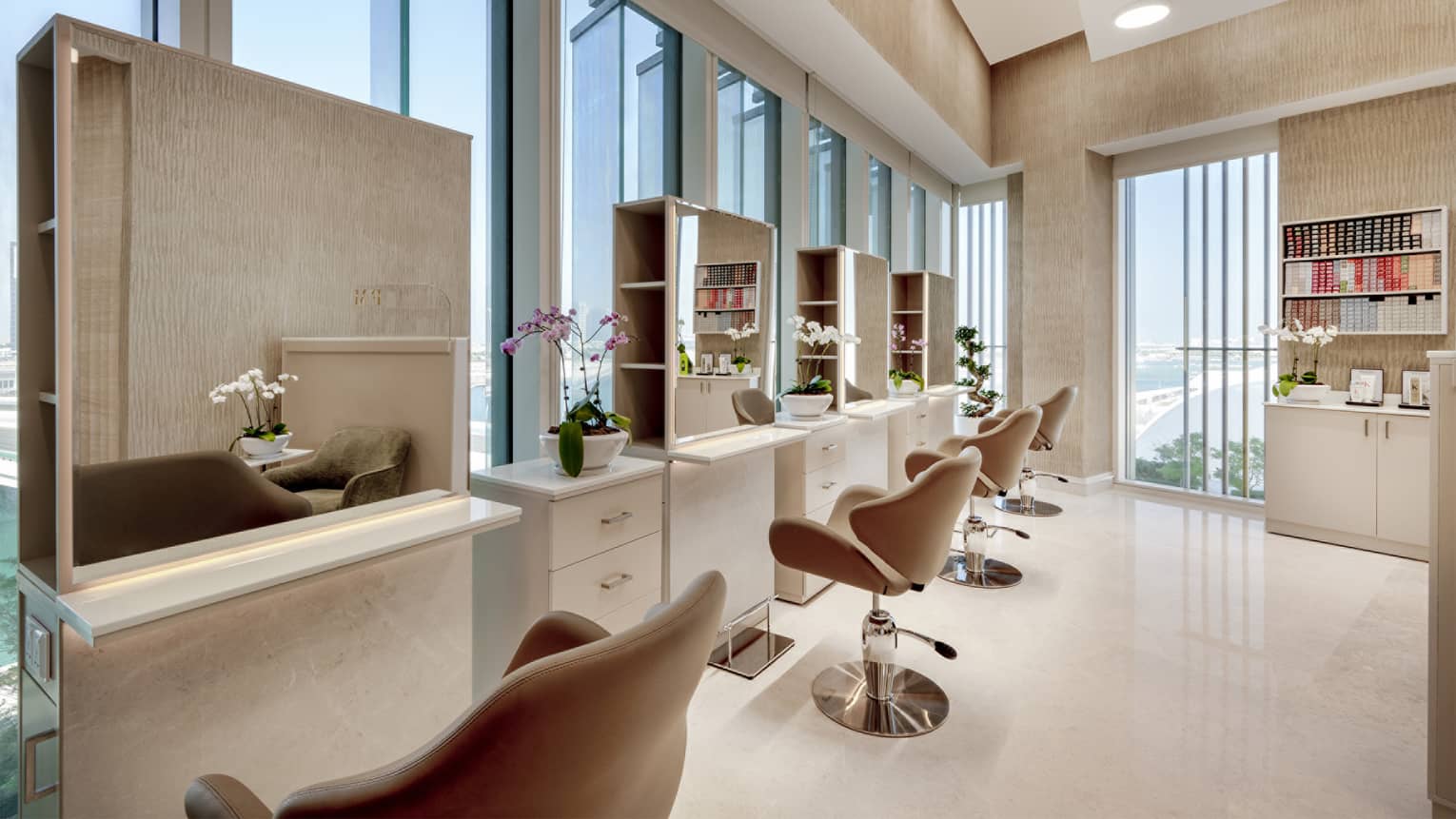 Hair salon with four stations and vanities set along floor-to-ceiling windows