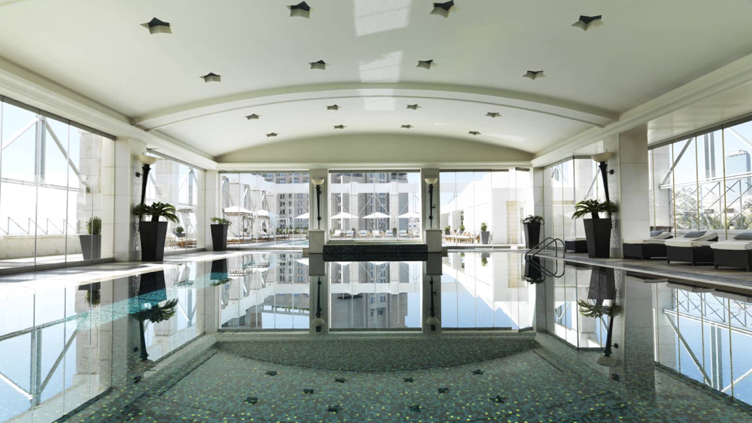 A long shot of a blue pool with mosaic tile.