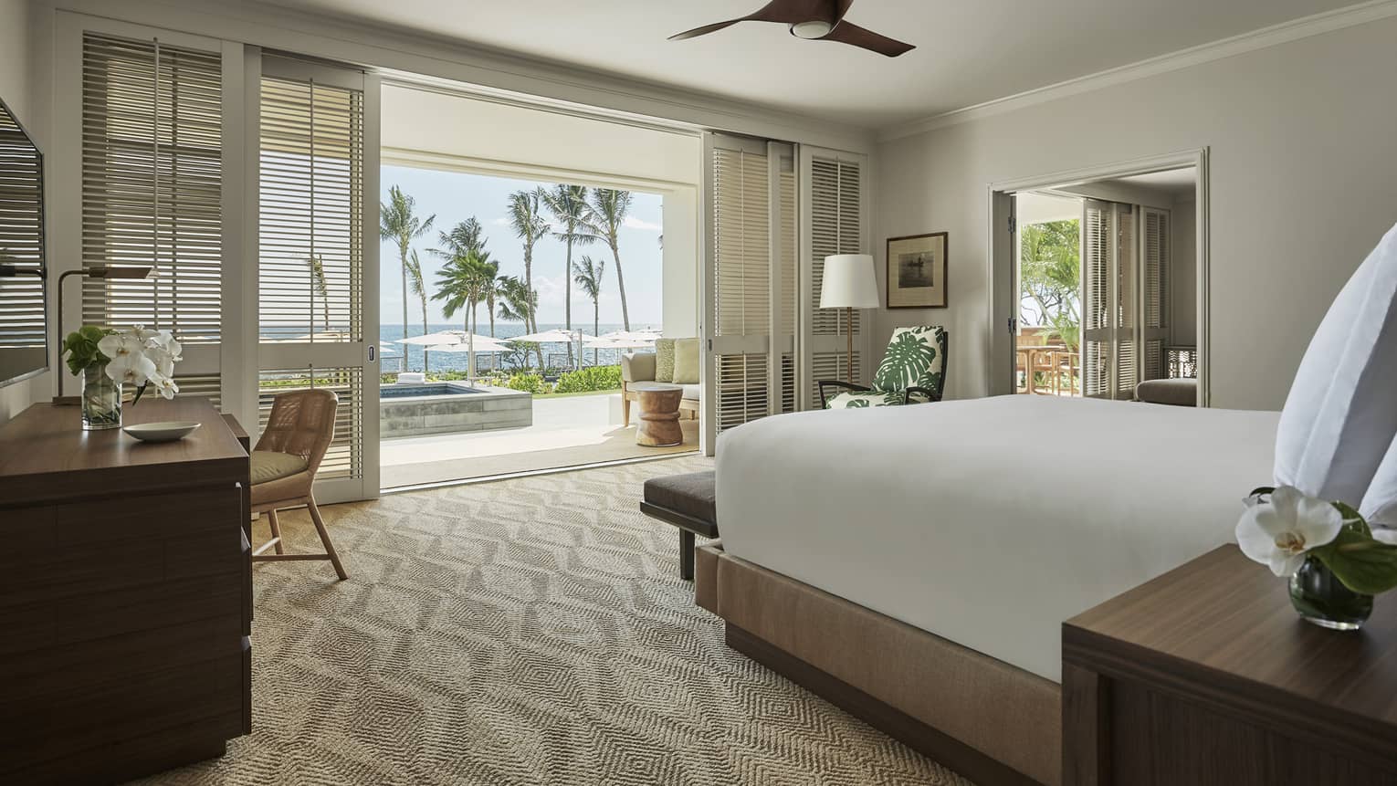 Pacific Suite bedroom, desk, end of bed facing sliding white shutters to balcony