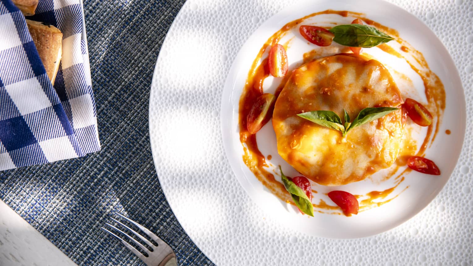 an aerial shot of a tomato and egg dish with basil on top in Four Seasons Maldives - Landaa