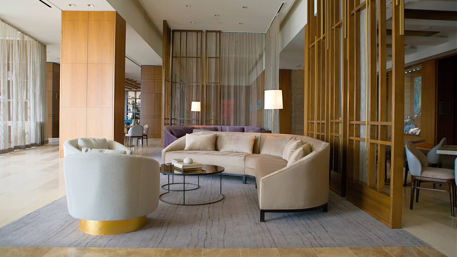 A seating area with a large sofa, coffee table, and chair.