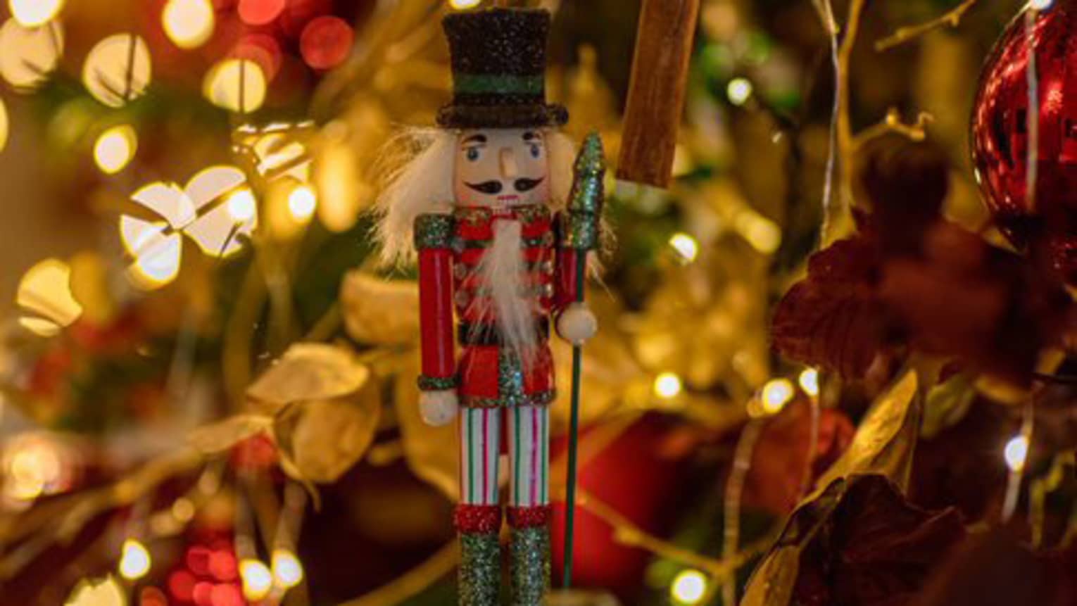 A nutcracker ornament on a Christmas tree.