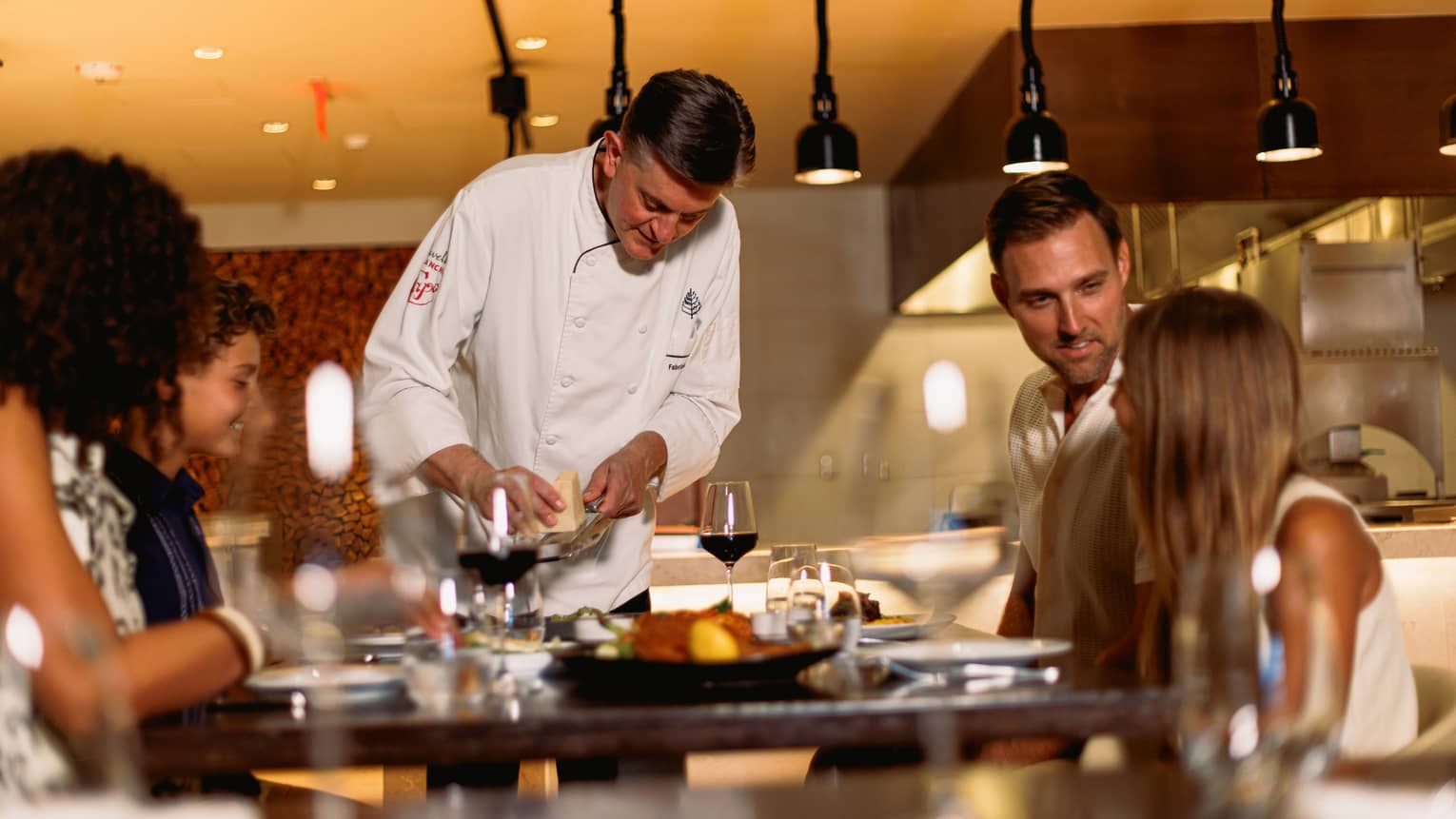 Chef prepares a meal table-side for a family of four