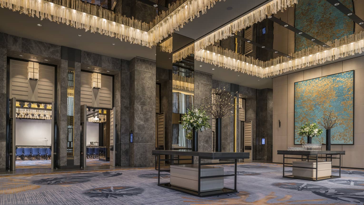 Beautiful Grand Ballroom Foyer with chandeliers, flowers and artwork on wall 