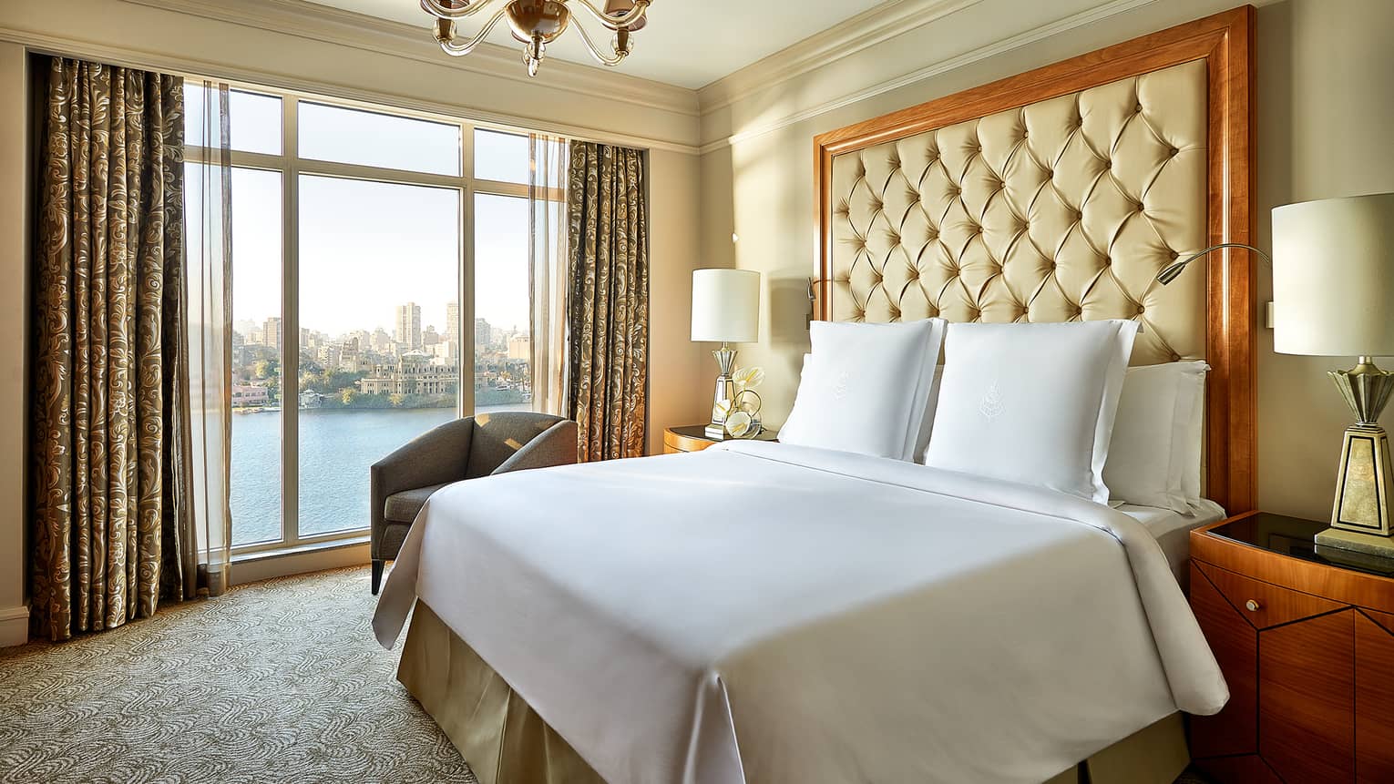 Diplomatic Suite bed with large tufted headboard by floor-to-ceiling window