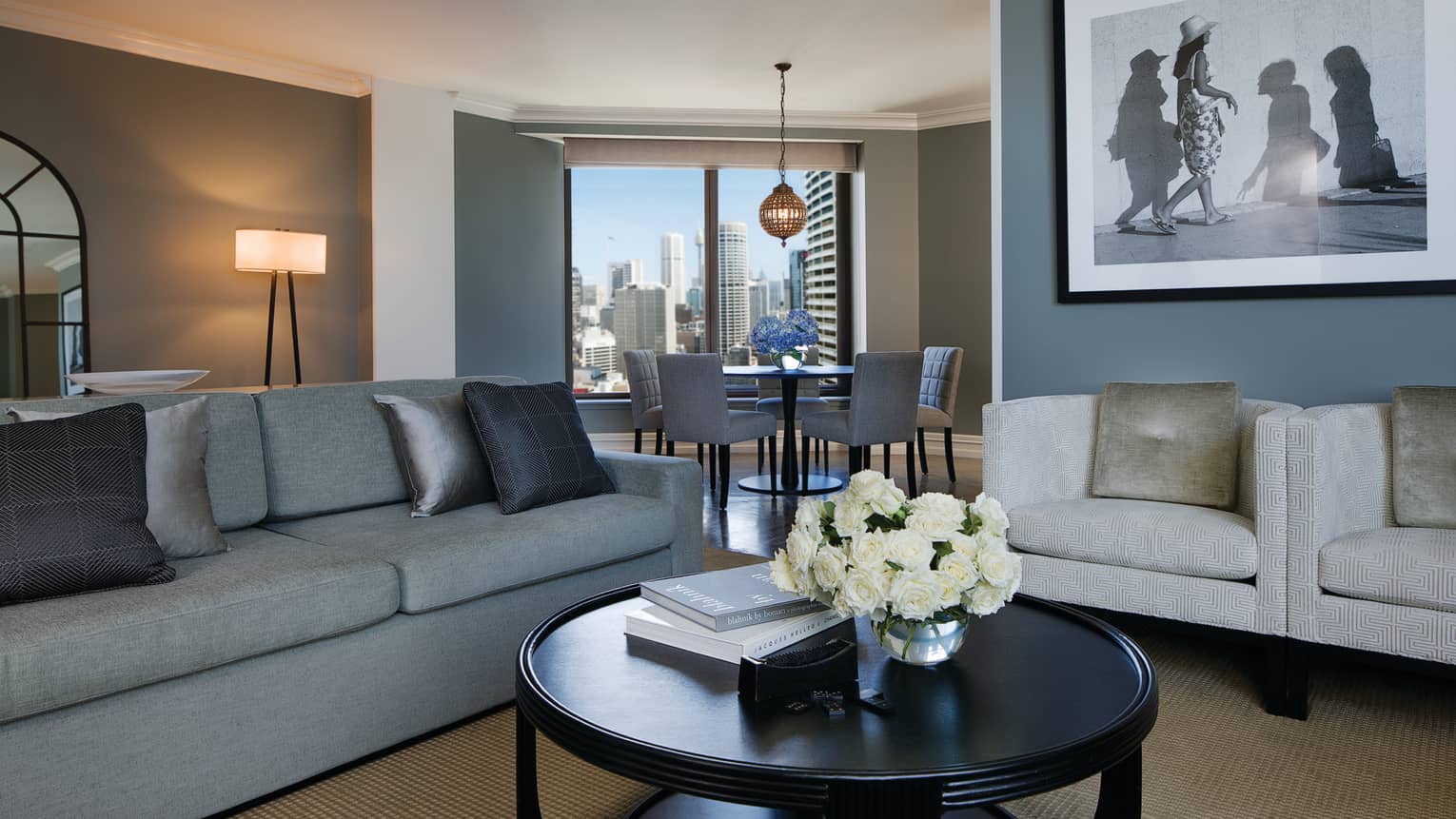 Royal Suite sofa with silver pillows, round table, black-and-white framed print, dining alcove