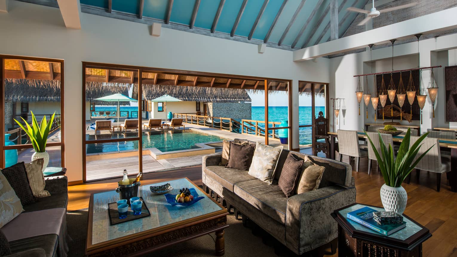 Three-Bedroom Land and Ocean Suite living room sofas around table with fresh fruit, beer on ice