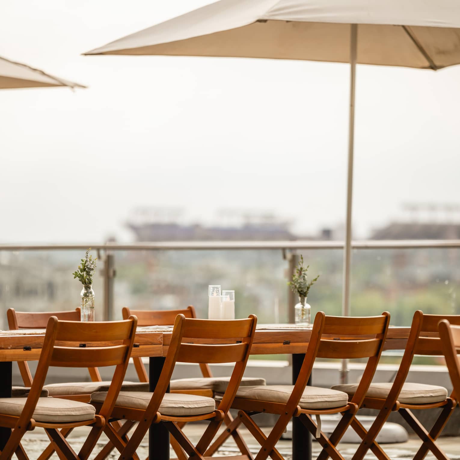 A table and chairs with umbrellas set up outside on a rooftop terrace