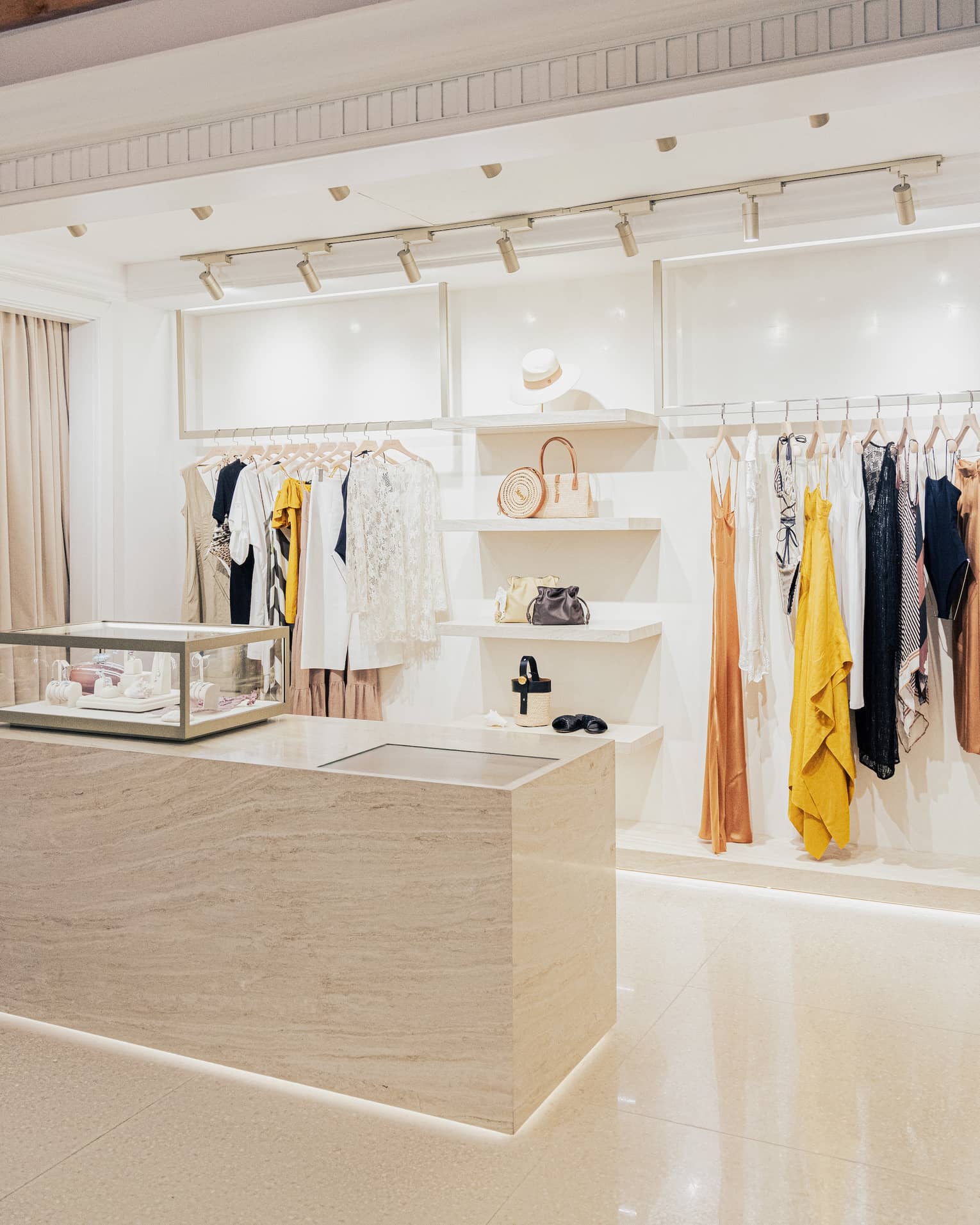 Contemporary boutique with white shelving and stylish clothes