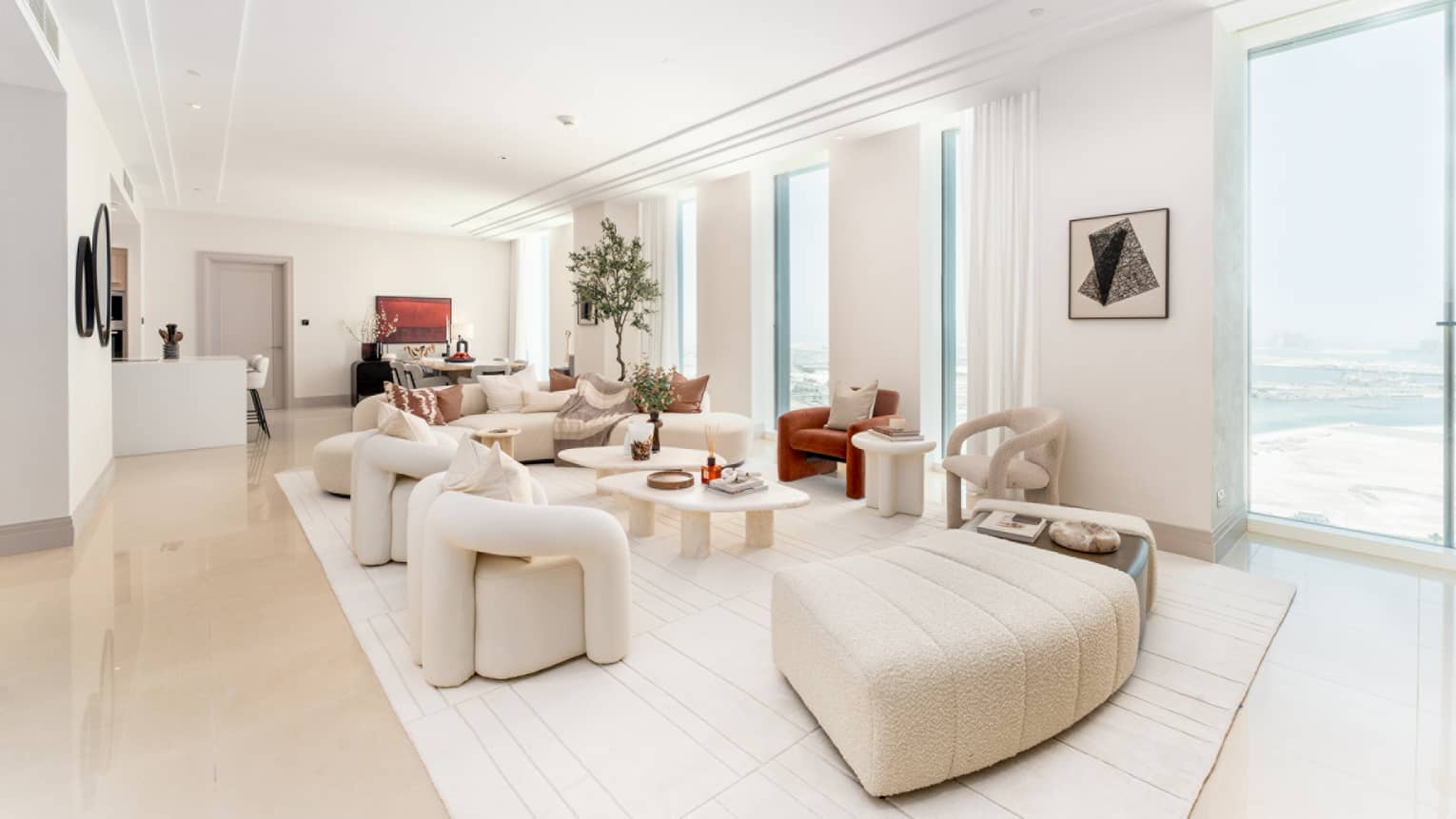 Living room area with seats and floor-to-ceiling windows with view of the sea