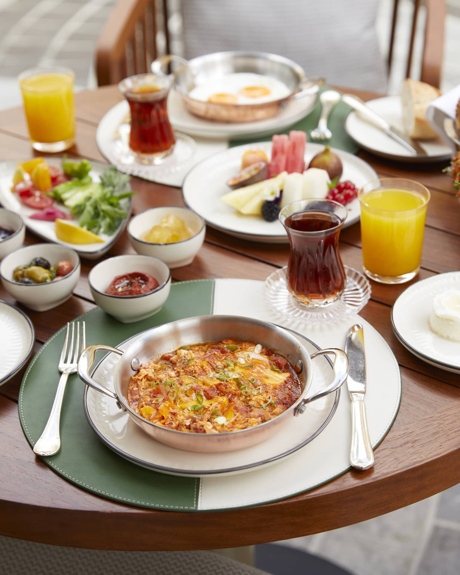 Breakfast meals, olives, cheeses and juices on patio dining table