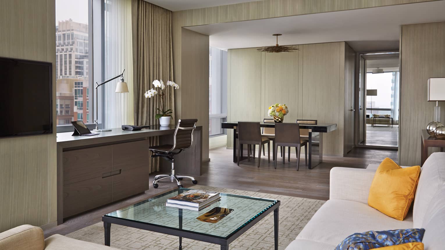 Yorkville Suite living room, glass table, desk under window, dining room by bedroom door