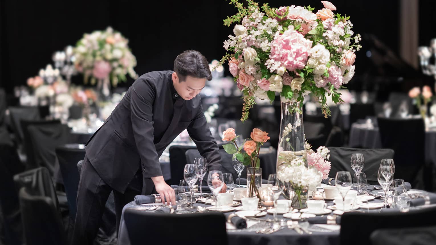 Man sets table for wedding in an event venue