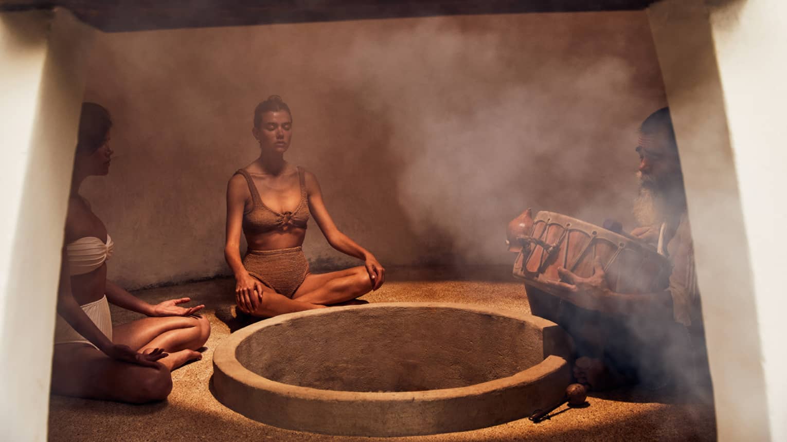 Three people sitting in a heated room with steam.